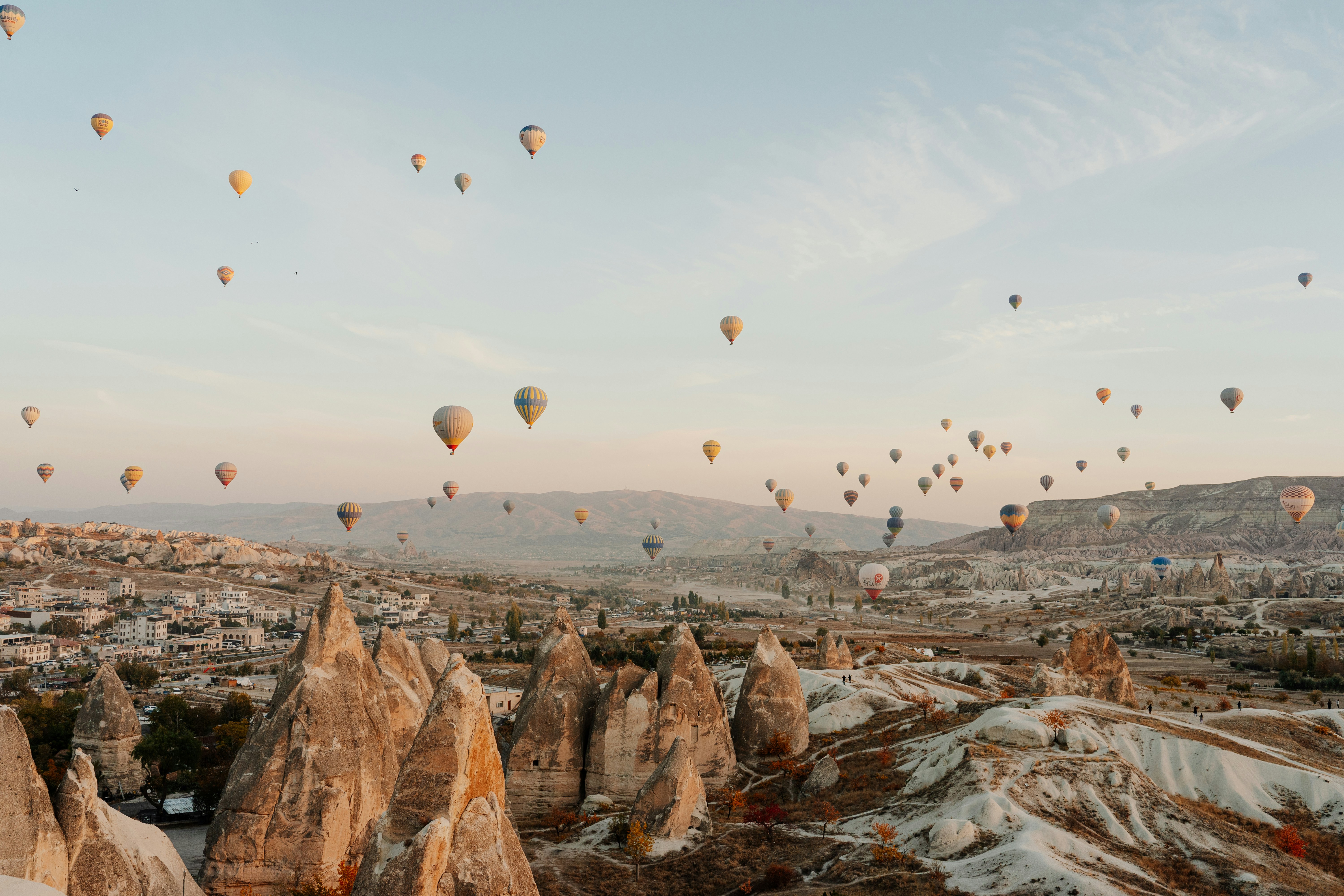 Hot air balloons floating over Cappadocia fairy chimneys at sunrise